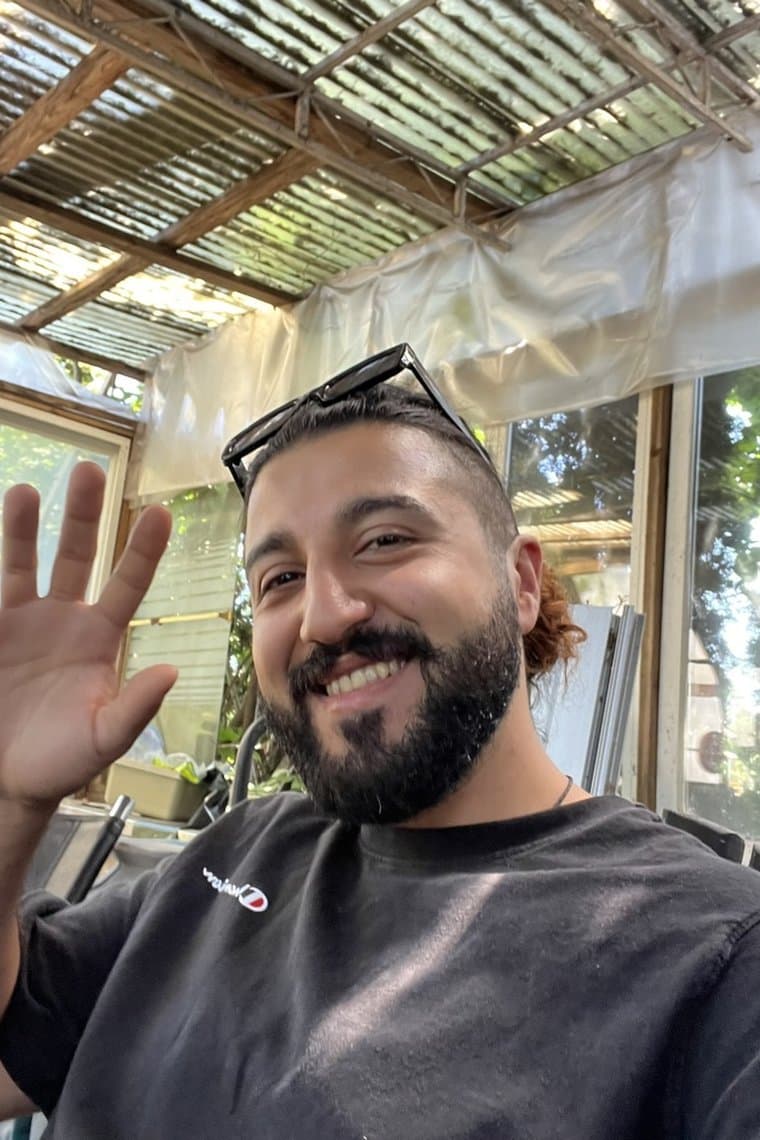 Waving and smiling in a garden greenhouse